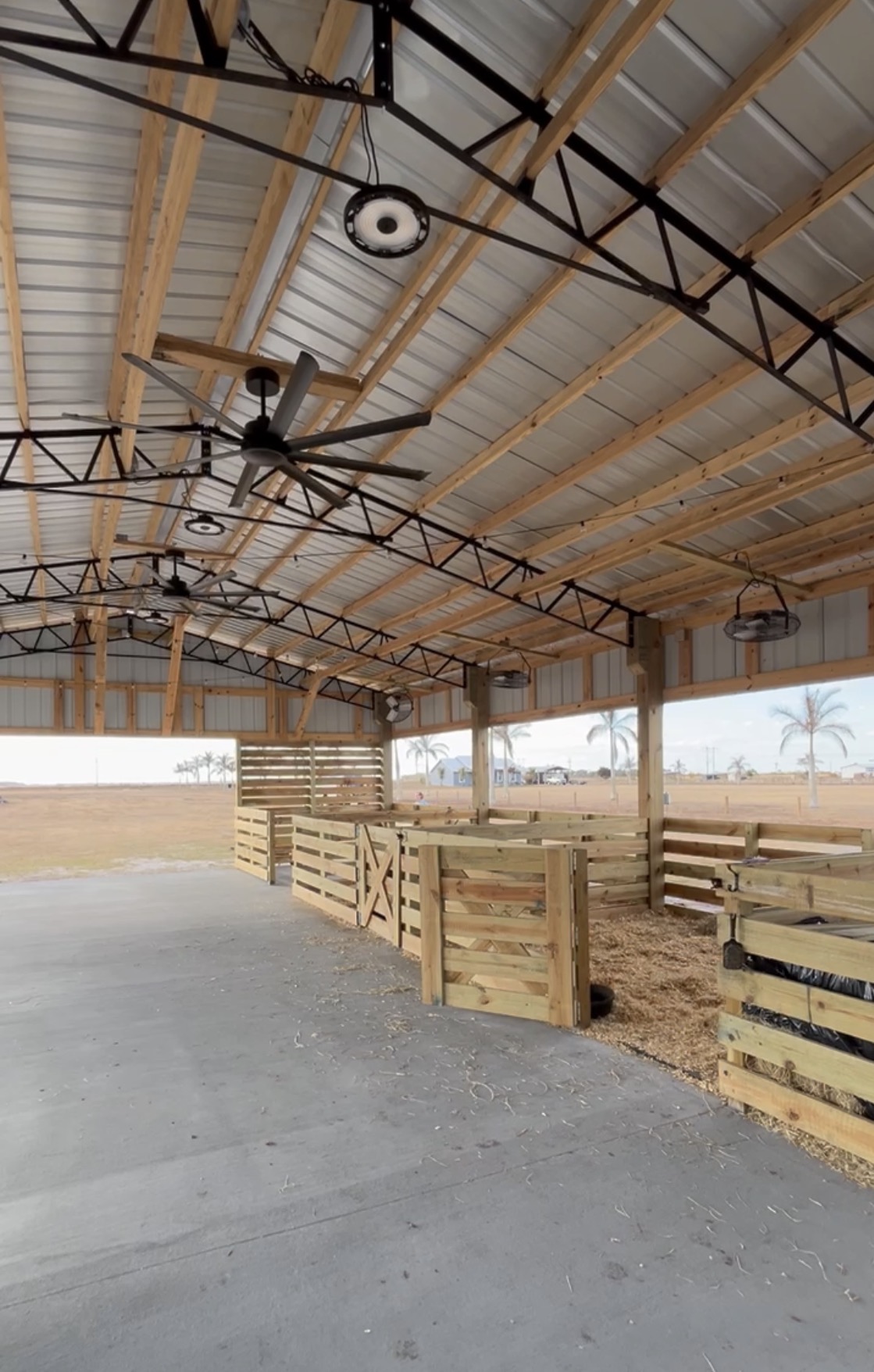 Dekker-built South Florida open pole barn pavilion with wood posts, metal roof, and livestock stalls